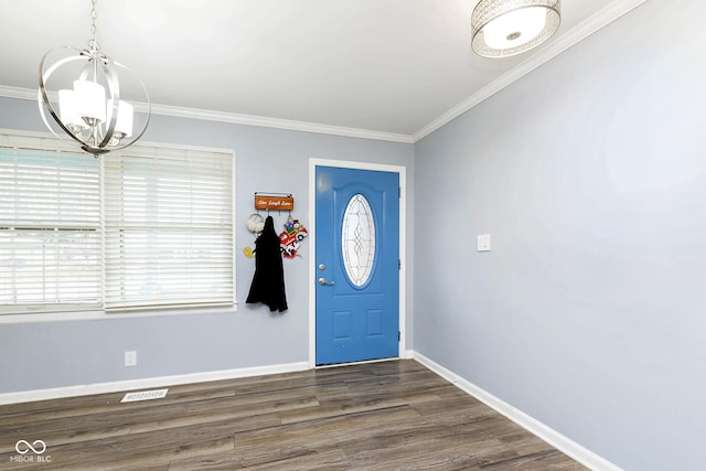 foyer entrance featuring dark hardwood / wood-style flooring, crown molding, and an inviting chandelier