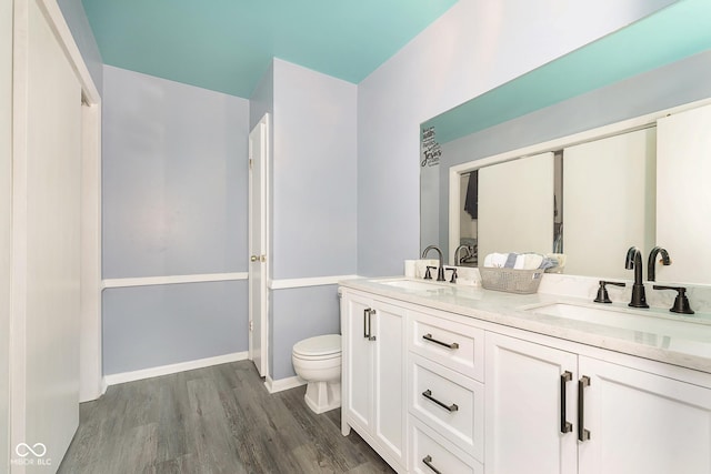 bathroom with hardwood / wood-style floors, vanity, and toilet