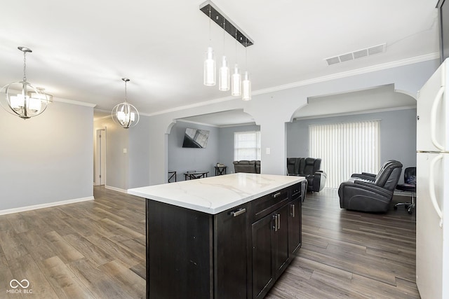 kitchen featuring white fridge, a kitchen island, light hardwood / wood-style floors, and crown molding