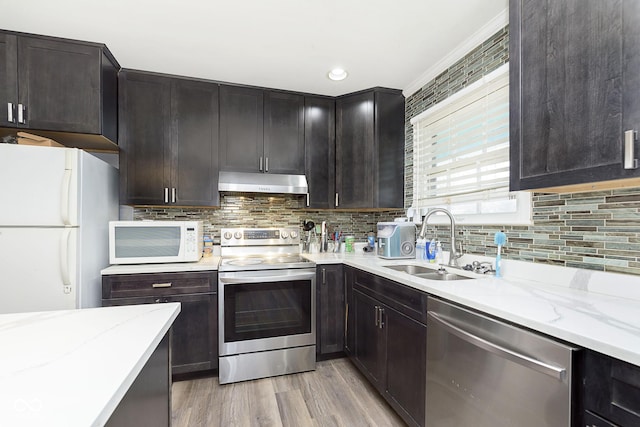 kitchen featuring backsplash, sink, light hardwood / wood-style floors, and appliances with stainless steel finishes