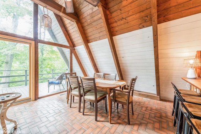 dining space with vaulted ceiling with beams, wooden ceiling, and wood walls