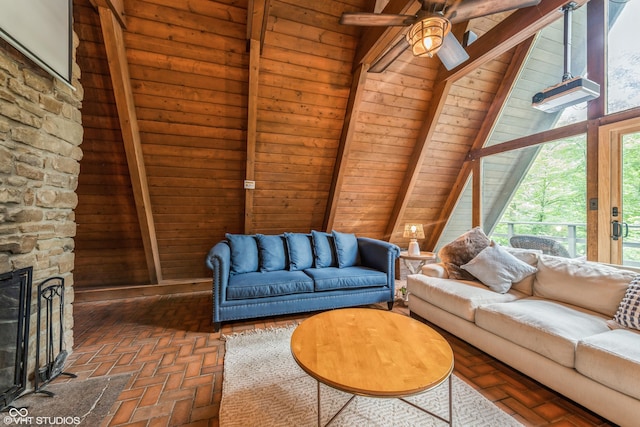 living room featuring ceiling fan, wooden ceiling, a stone fireplace, beamed ceiling, and high vaulted ceiling