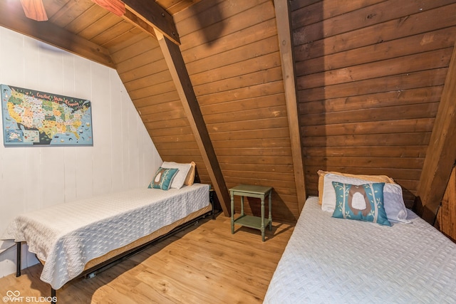 bedroom with hardwood / wood-style floors, vaulted ceiling with beams, wood ceiling, and wooden walls