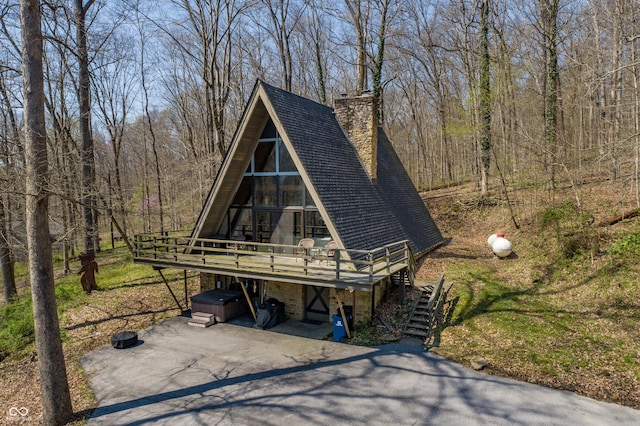 view of front facade with a wooden deck and a hot tub