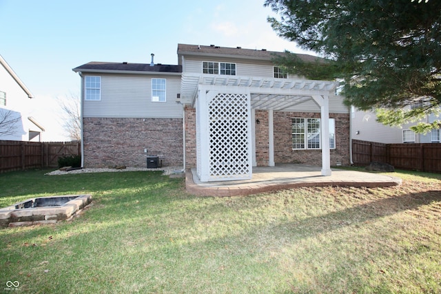 rear view of house with a pergola, central AC, an outdoor fire pit, a patio area, and a yard