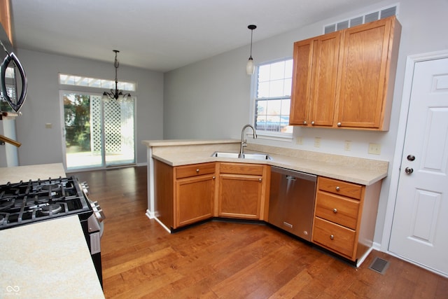 kitchen featuring dishwasher, dark hardwood / wood-style floors, sink, and decorative light fixtures