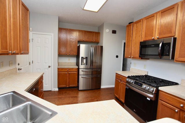 kitchen with stainless steel appliances, dark hardwood / wood-style floors, and sink