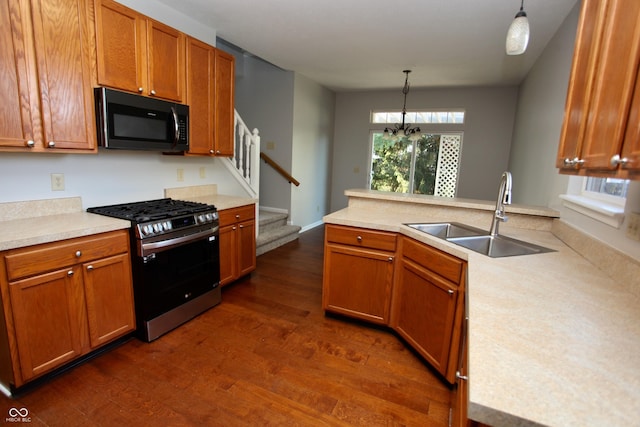 kitchen featuring pendant lighting, gas stove, dark hardwood / wood-style flooring, and sink