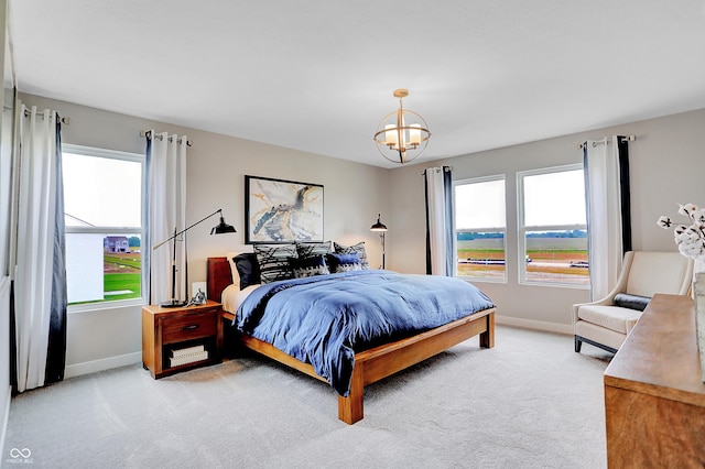 bedroom with a chandelier and light colored carpet