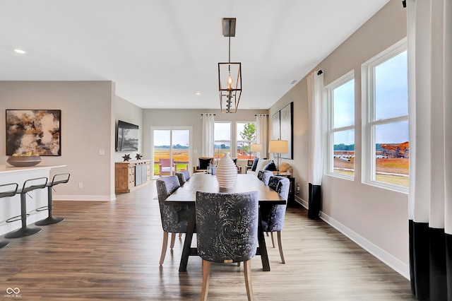 dining area featuring light hardwood / wood-style floors and an inviting chandelier