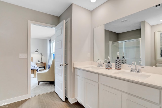 bathroom featuring hardwood / wood-style flooring, vanity, and a shower with shower door