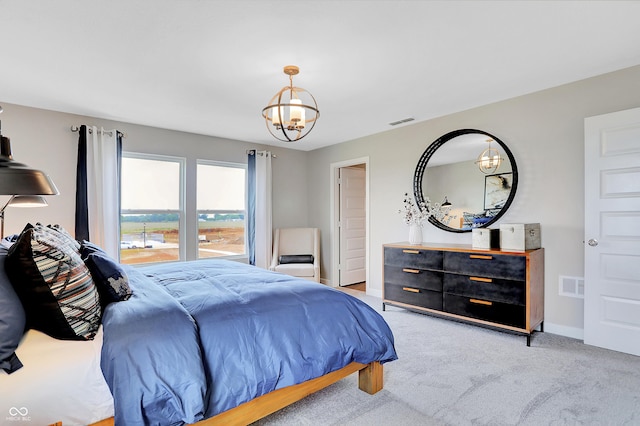 carpeted bedroom featuring an inviting chandelier