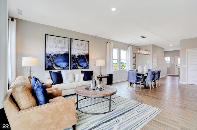 living room featuring an inviting chandelier and hardwood / wood-style flooring