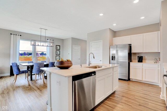 kitchen featuring white cabinetry, sink, appliances with stainless steel finishes, and an island with sink