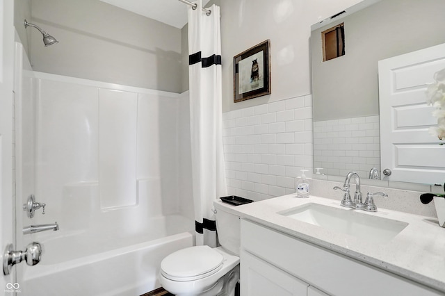 full bathroom with tile walls, vanity, shower / bath combo, and toilet