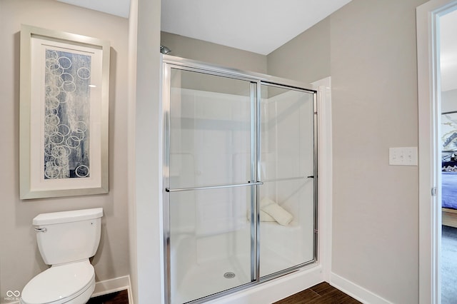 bathroom with toilet, wood-type flooring, and walk in shower