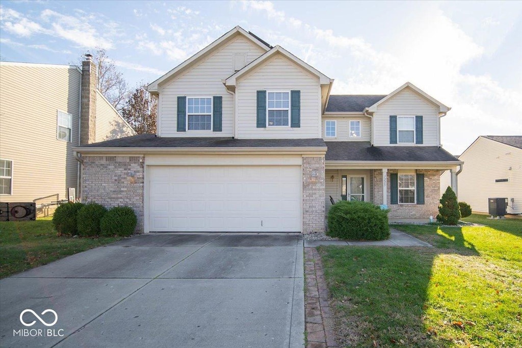 view of front of home with a front lawn, a garage, and cooling unit