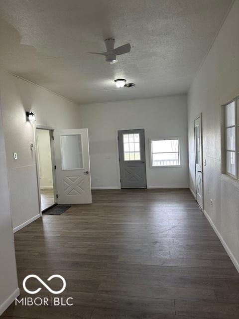 unfurnished room featuring dark hardwood / wood-style floors, ceiling fan, and a textured ceiling