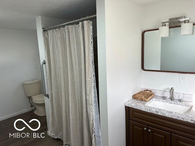 bathroom featuring hardwood / wood-style floors, vanity, toilet, and a shower with shower curtain