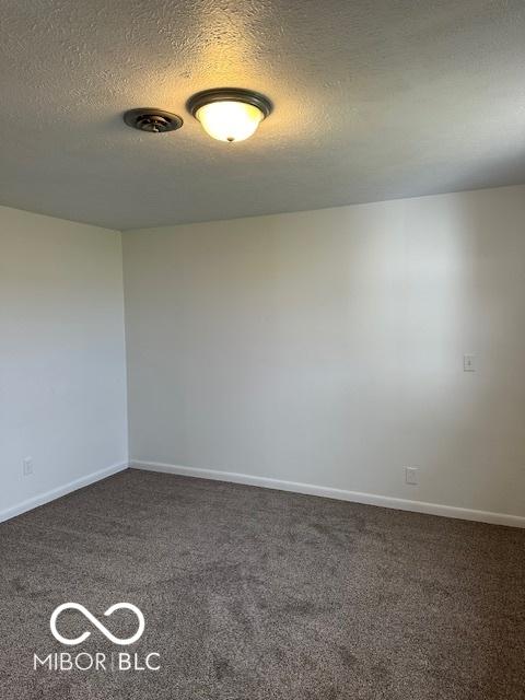 carpeted spare room with a textured ceiling