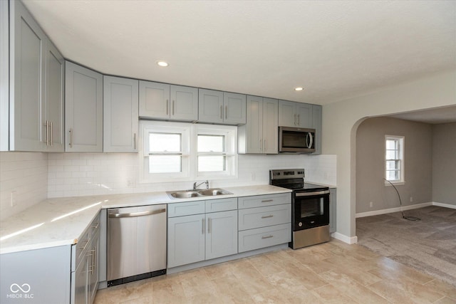 3060 S Shortridge Rd, Indianapolis, IN 46239 - kitchen with appliances with stainless steel finishes, gray cabinets, arched walkways, light countertops, and recessed lighting