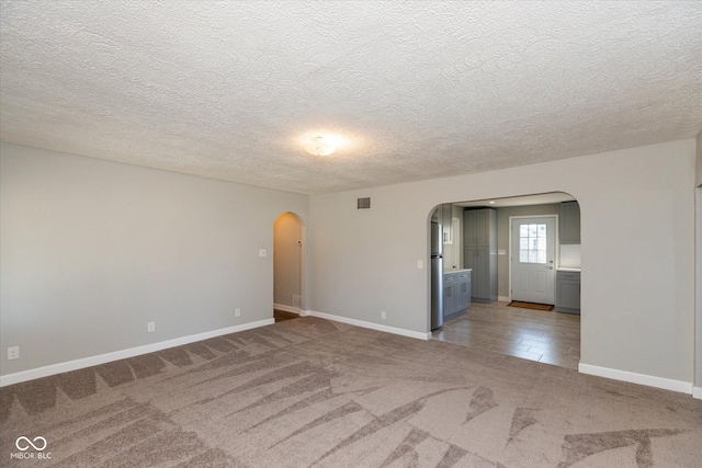 3060 S Shortridge Rd, Indianapolis, IN 46239 - empty room with arched walkways, light carpet, and a textured ceiling