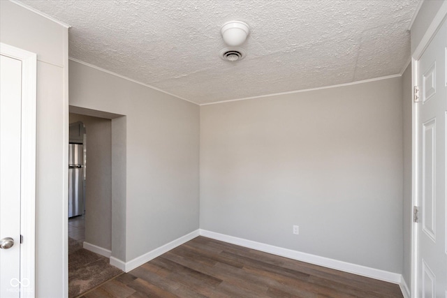 empty room featuring dark wood-type flooring and a textured ceiling