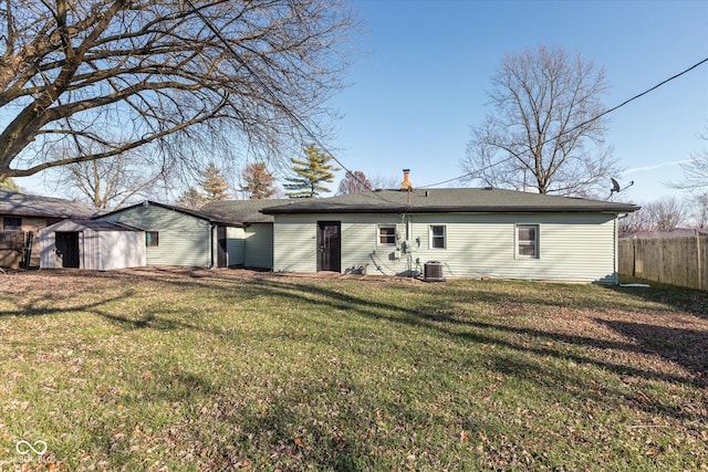 back of house with a yard, cooling unit, and a storage shed