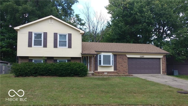 tri-level home featuring a front yard and a garage