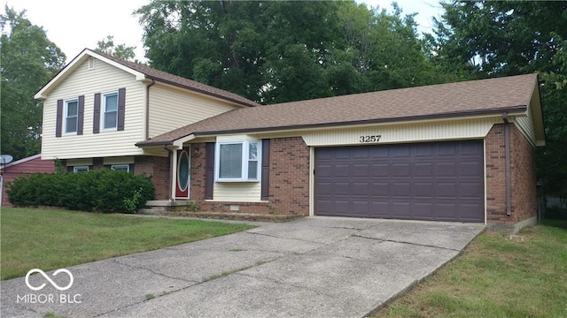 tri-level home featuring a garage and a front yard