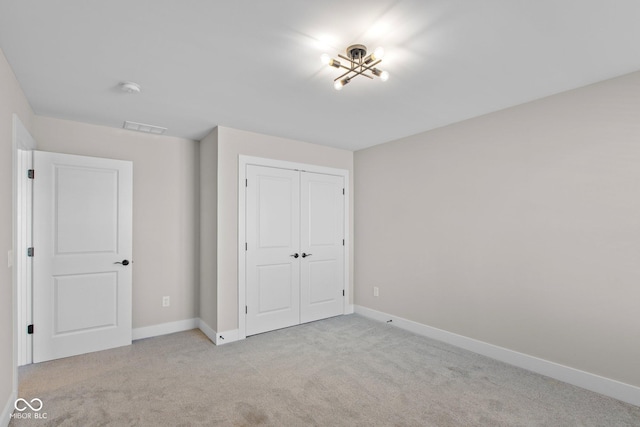 unfurnished bedroom with light carpet and a closet