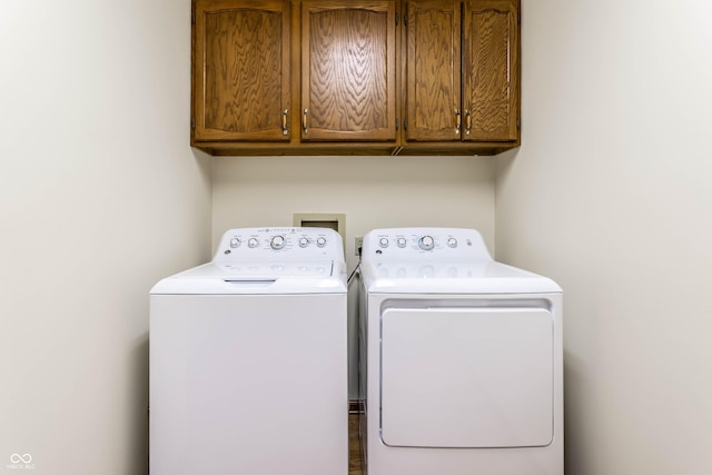 washroom featuring cabinets and washing machine and dryer