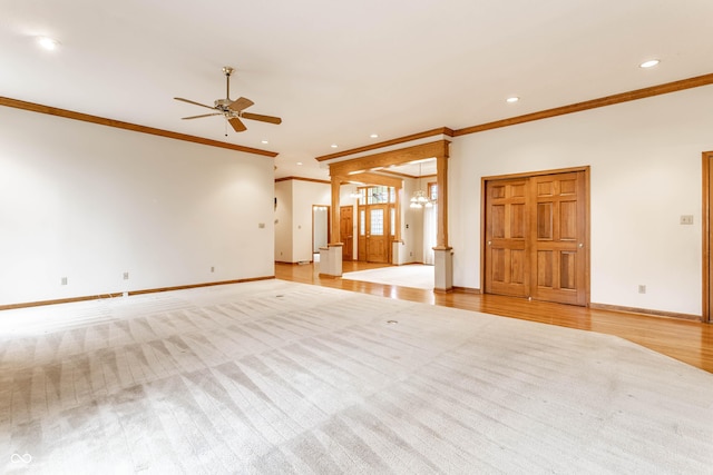 unfurnished living room featuring crown molding, ceiling fan with notable chandelier, and light wood-type flooring