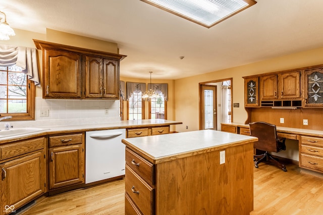 kitchen featuring dishwasher, a center island, decorative light fixtures, and light hardwood / wood-style floors