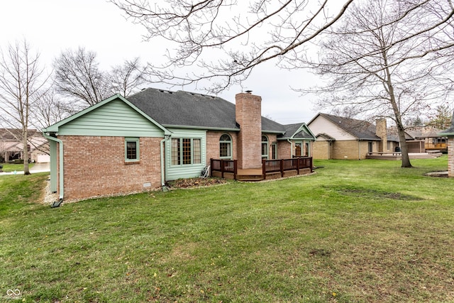 rear view of house featuring a lawn and a wooden deck