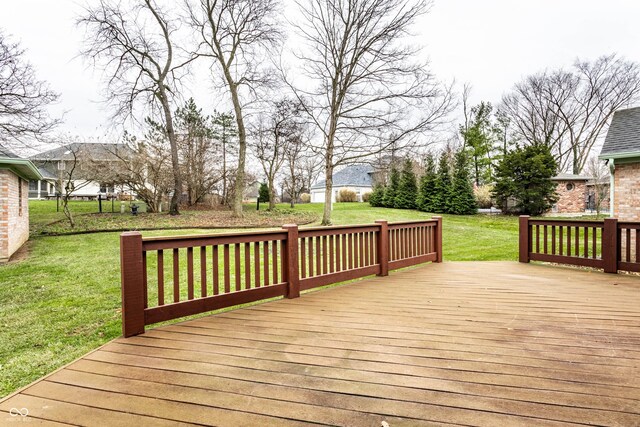 wooden terrace featuring a lawn