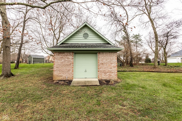 view of outdoor structure with a lawn and a garage