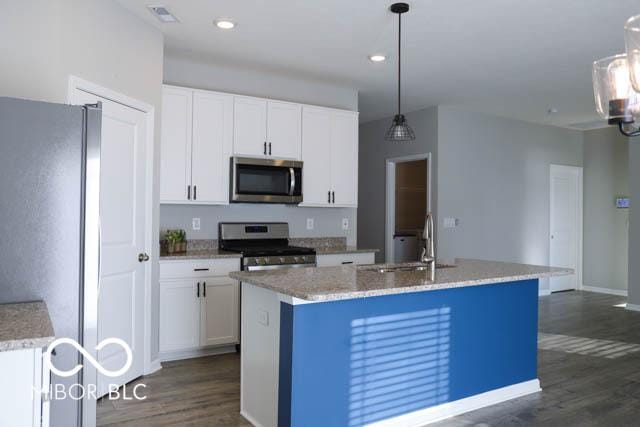 kitchen with white cabinets, sink, a kitchen island with sink, and appliances with stainless steel finishes