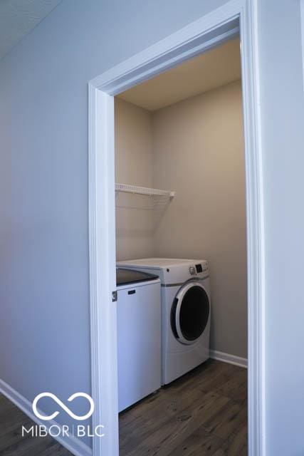 laundry area with dark wood-type flooring and independent washer and dryer