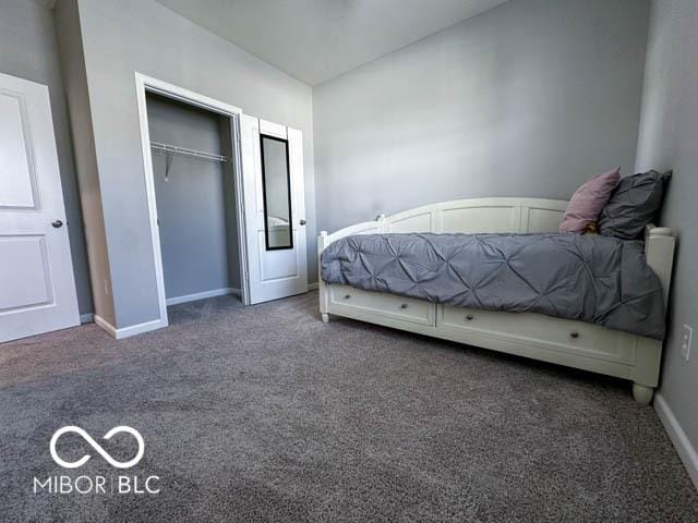 unfurnished bedroom featuring dark colored carpet and a closet