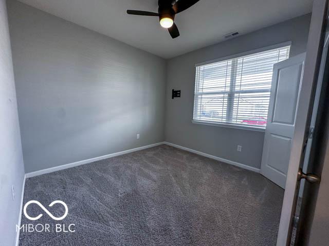 carpeted spare room featuring ceiling fan