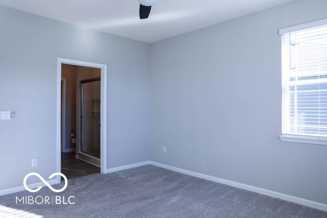 unfurnished bedroom featuring ceiling fan and dark carpet