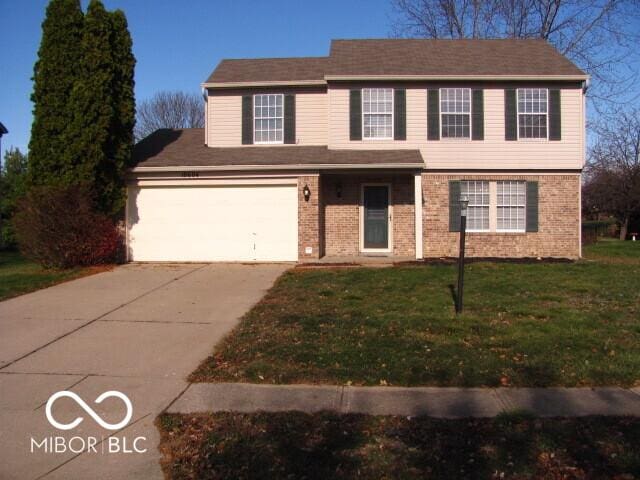 view of front of property with a garage and a front lawn