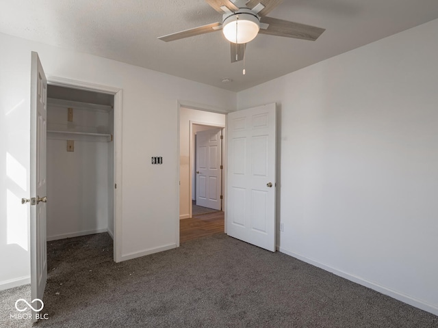 unfurnished bedroom with ceiling fan, a closet, and dark colored carpet