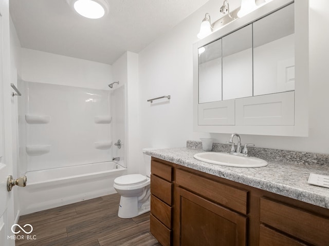 full bathroom with hardwood / wood-style flooring, vanity, toilet, and shower / washtub combination