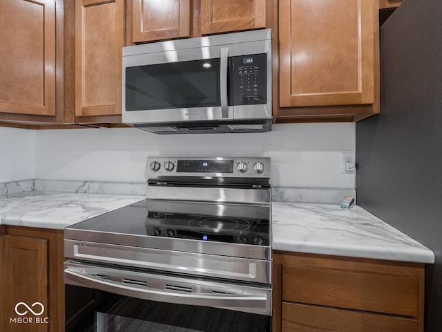 kitchen featuring light stone counters and stainless steel appliances