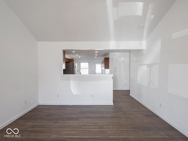 unfurnished living room with dark hardwood / wood-style flooring and lofted ceiling