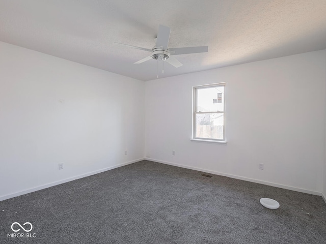 unfurnished room featuring ceiling fan, dark carpet, and a textured ceiling