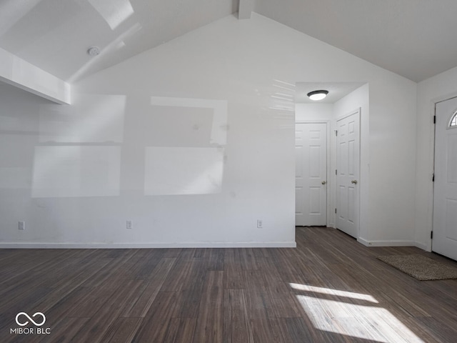 empty room with vaulted ceiling with beams and dark hardwood / wood-style flooring