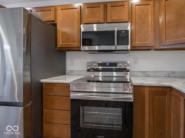 kitchen featuring light stone counters and appliances with stainless steel finishes